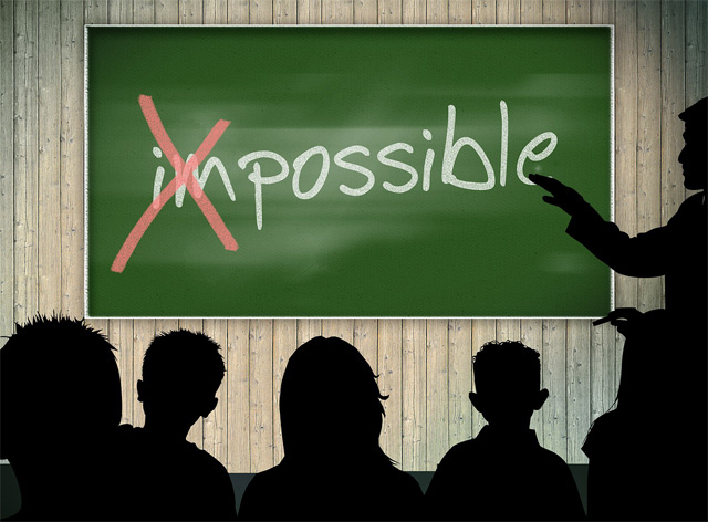 image of classroom chalkboard with 'impossible' written in chalk, the 'i' and 'm' have been crossed out to show the word 'possible'